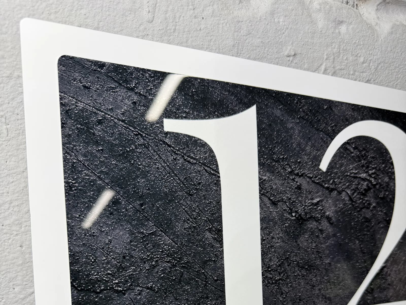 Macro close-up of colour and UV-laminated surface texture on a glossy Bolot Studio Address Sign
