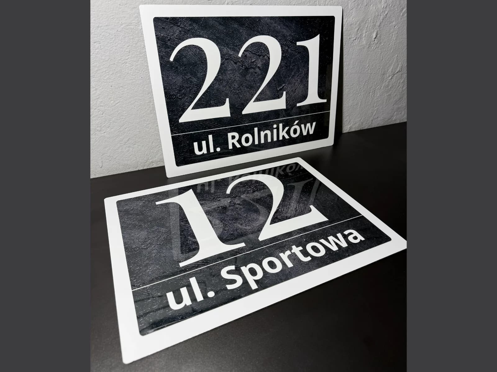 Two Bolot Studio address signs stacked together showing different glossy metal template designs side by side